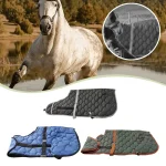 Winter horse blankets in various colors displayed near a horse by a lake